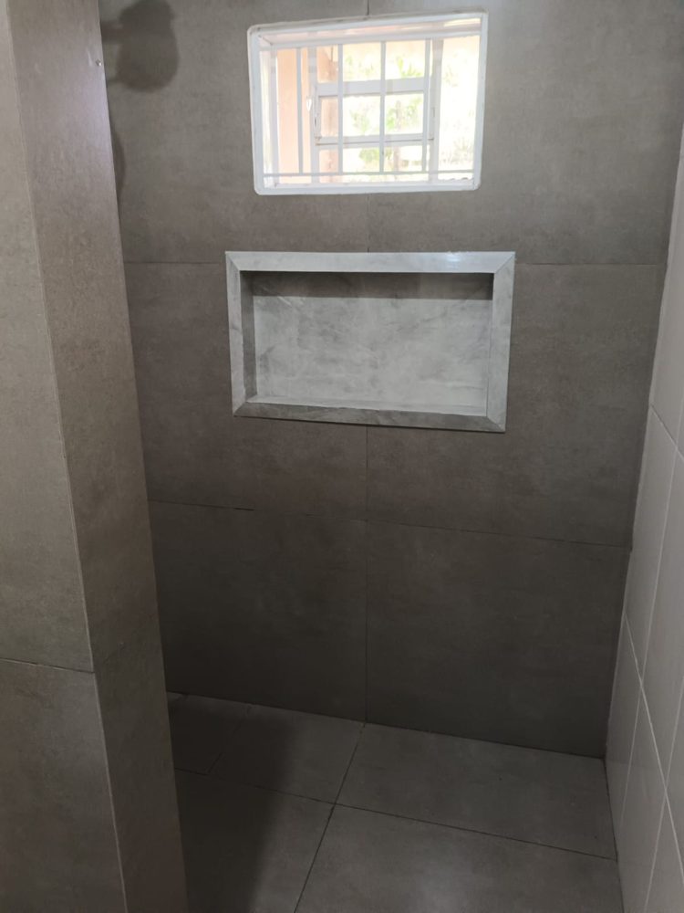 Box com nicho embutido e janela em porcelanato escuro
