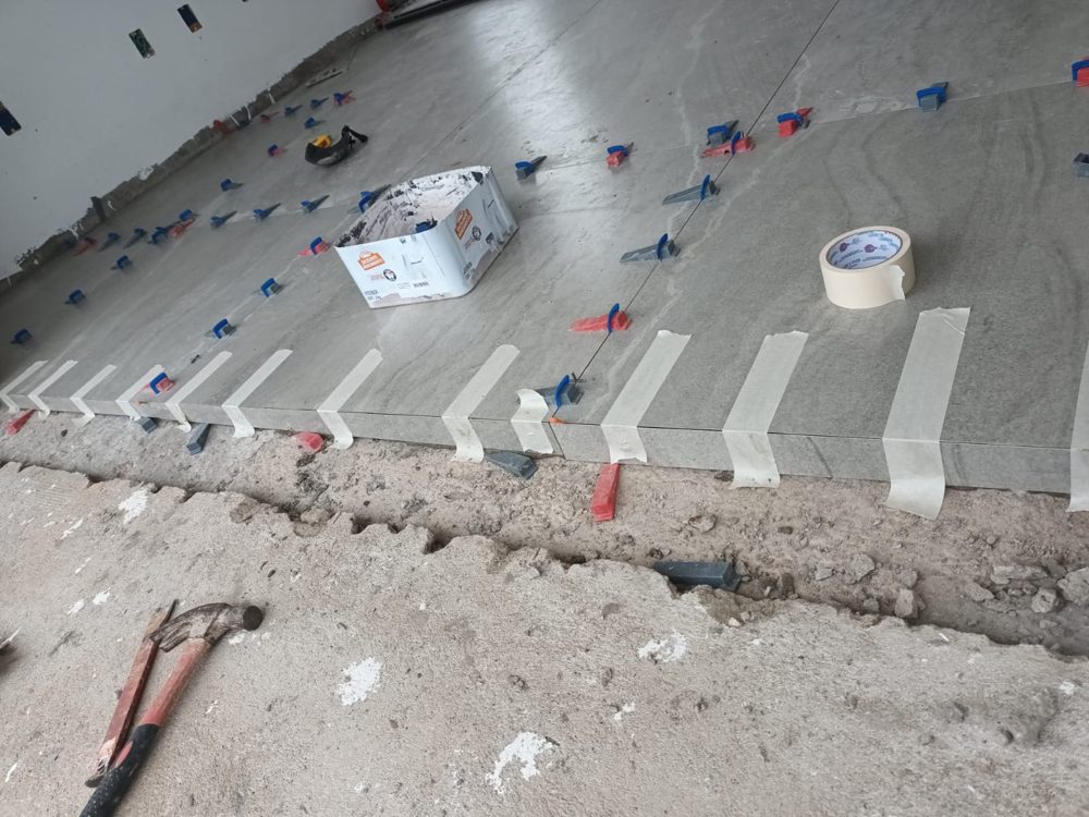 Piso de porcelanato em nivelamento com espaçadores e fita